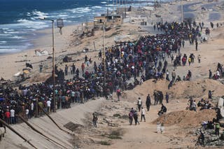 Displaced Palestinians walk along the coastal road near Gaza Wadi and move to northern Gaza